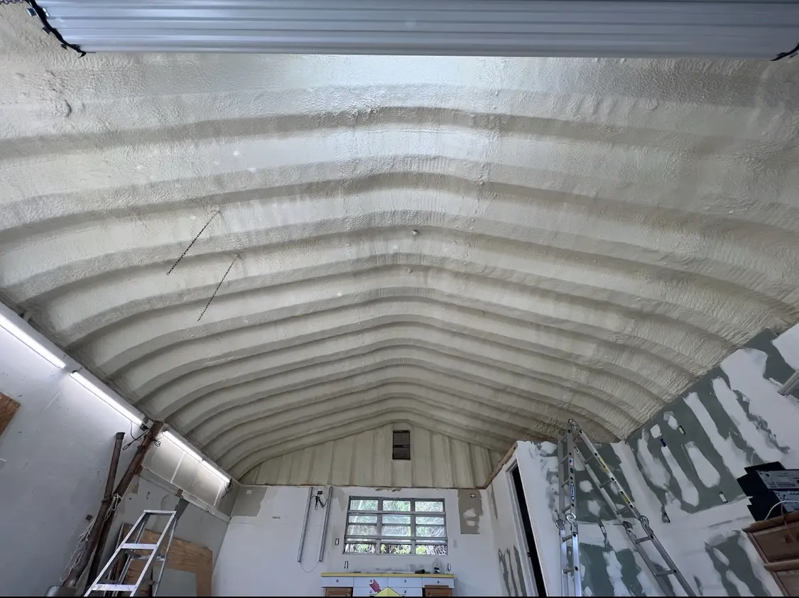 Spray polyurethane foam applied to the underside of a metal roof deck in Carney